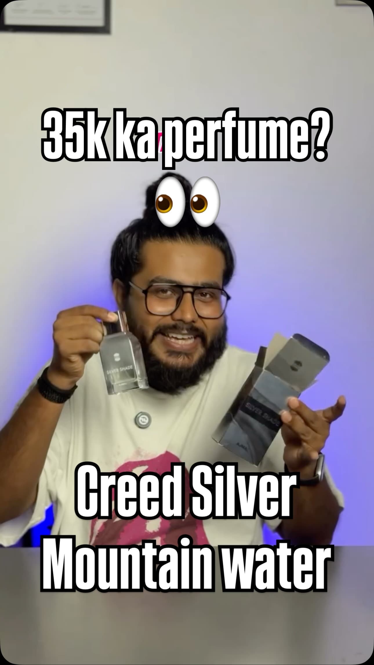 Akio holding a bottle of Ajmal Silver Shade and its box, with the text 'Creed Silver Mountain Water' on screen
